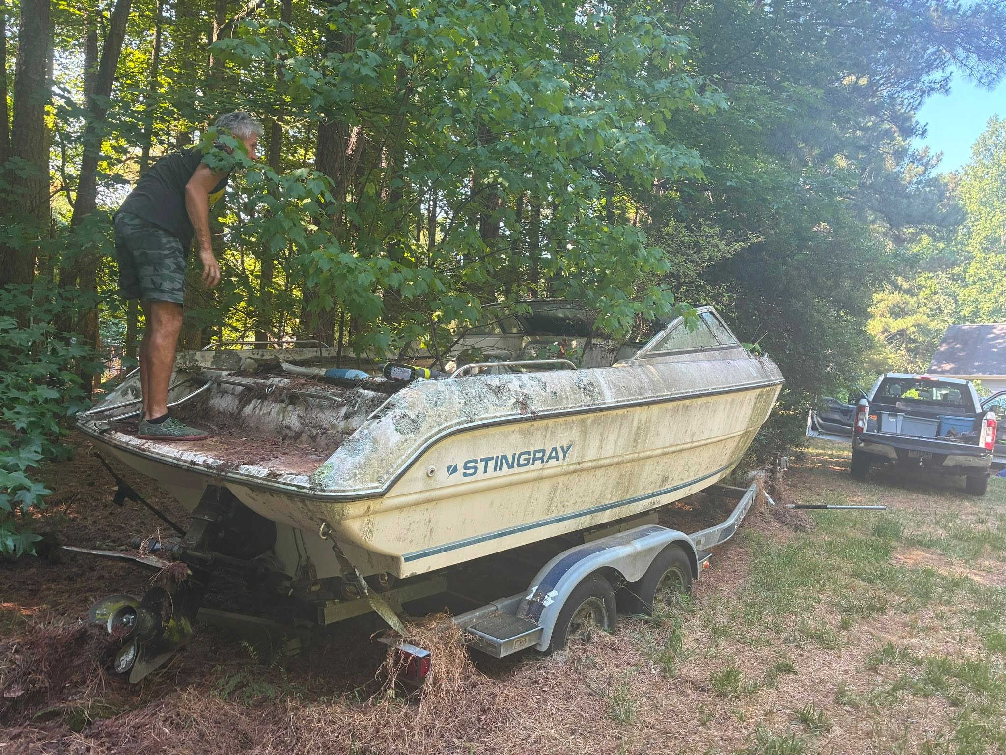Roberto clearing an old boat surrounded by trees